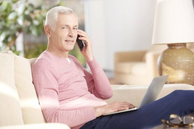 Dizüstü bilgisayar kullanan kıdemli adam.