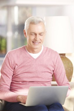 Dizüstü bilgisayar kullanan kıdemli adam.