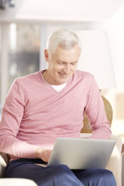 Dizüstü bilgisayar kullanan kıdemli adam.