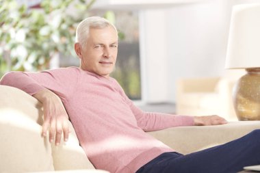 Kendine güvenen üst düzey adam evde kameraya bakan 