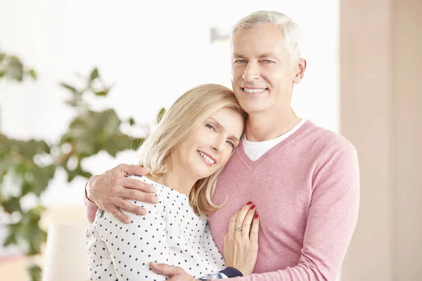 Senior man knuffelen vrouw thuis — Stockfoto