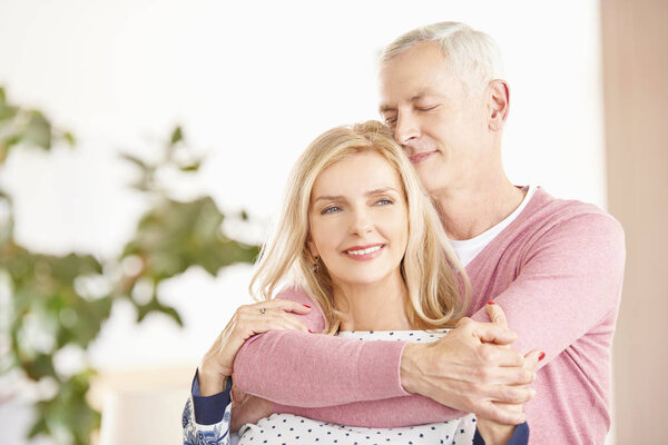 senior couple standing together in living room