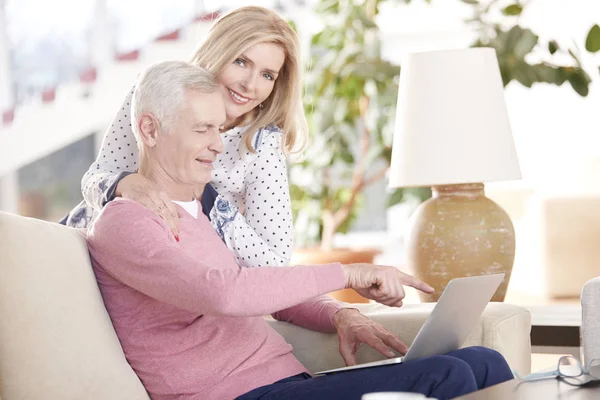 Oudere paar met behulp van een laptop thuis — Stockfoto