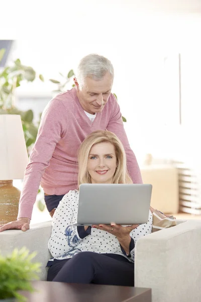 Äldres par använder en bärbar dator hemma — Stockfoto