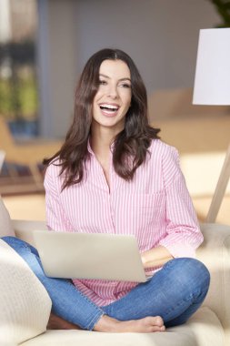 Evde bilgisayarını kullanan bir kadın.