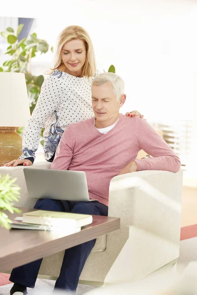 Pareja de ancianos utilizando el ordenador portátil en casa —  Fotos de Stock