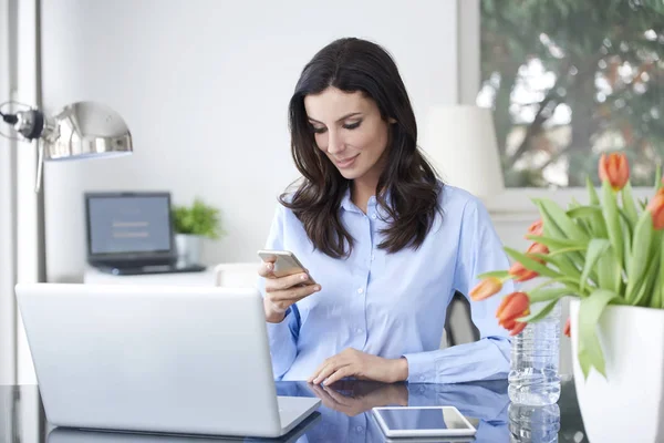 Jovem empresária sentada na frente do laptop — Fotografia de Stock