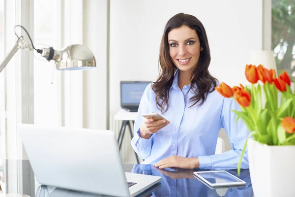 Jovem empresária sentada na frente do laptop — Fotografia de Stock