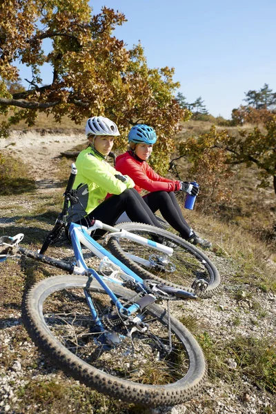 Горные велосипедисты отдыхают на склоне холма — стоковое фото