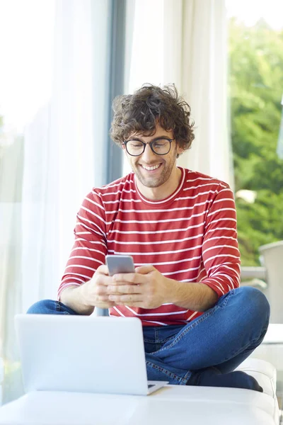 Hombre joven usando teléfono móvil — Foto de Stock