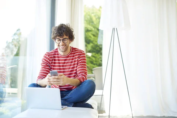 Hombre joven usando teléfono móvil — Foto de Stock