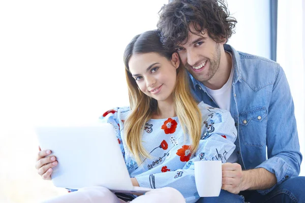 Casal jovem com laptop em casa — Fotografia de Stock