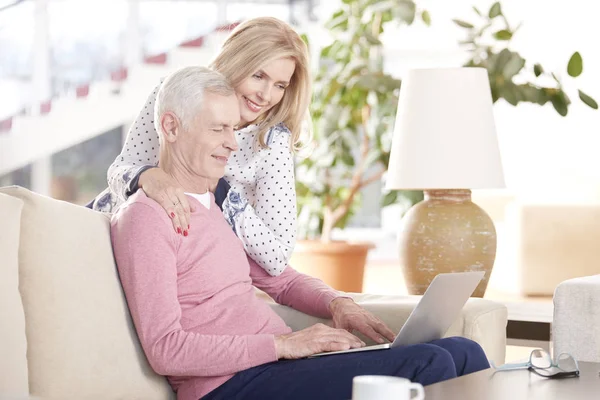 Lyckliga äldre par med laptop — Stockfoto