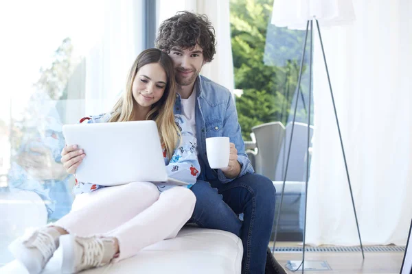 Paar ontspannen op de Bank met laptop — Stockfoto