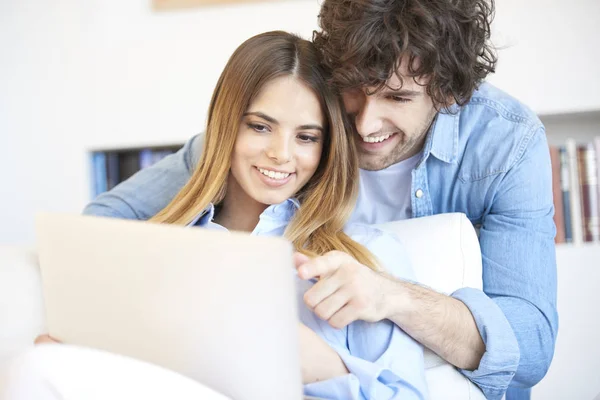 Casal sentado no sofá com laptop — Fotografia de Stock