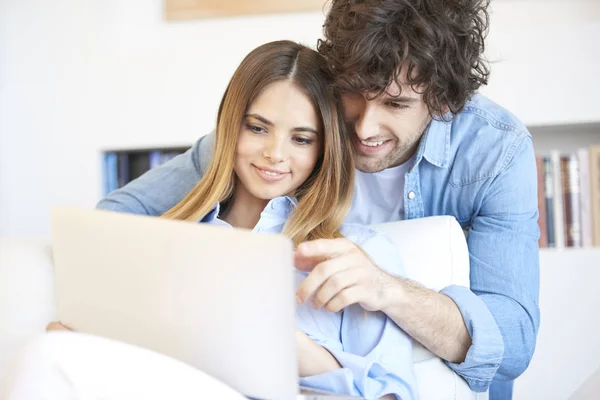 Pareja sentada en el sofá con portátil — Foto de Stock