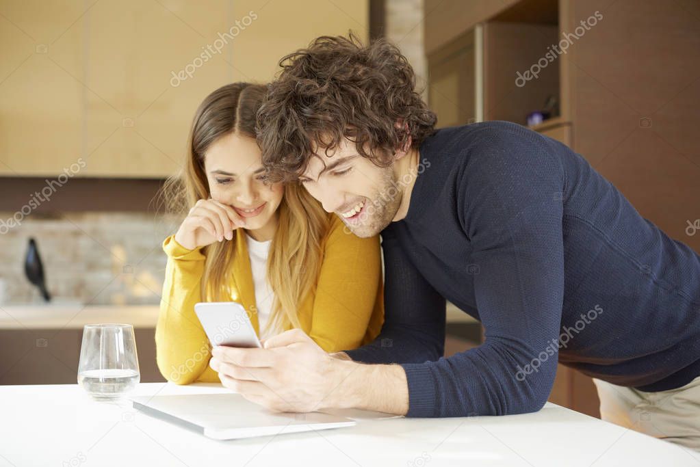 couple relaxing at home and text messages