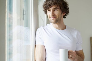 Elinde kahve tutan bir adam.