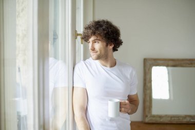 Elinde kahve tutan bir adam.