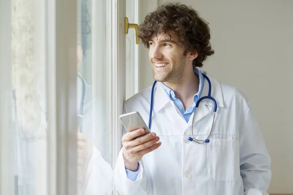 Médico usando seu telefone celular — Fotografia de Stock