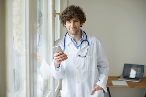 Läkare använder sin mobiltelefon — Stockfoto