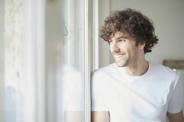 Joven feliz mirando por la ventana —  Fotos de Stock