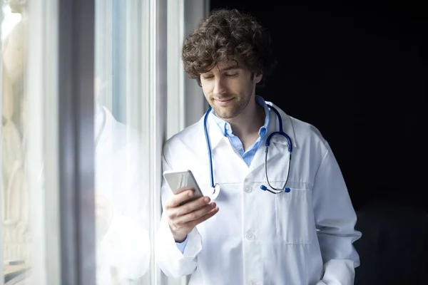 Médico usando telefone celular — Fotografia de Stock