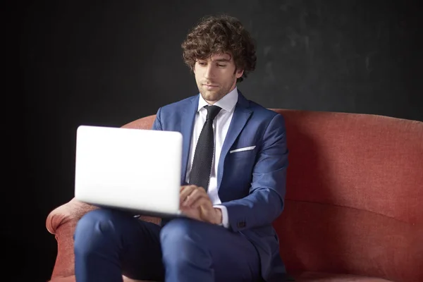 Selbstbewusster junger Geschäftsmann mit Laptop — Stockfoto
