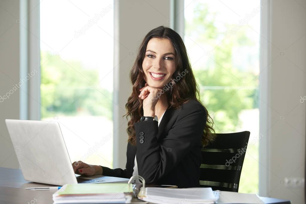 Confident young businesswoman with laptop 