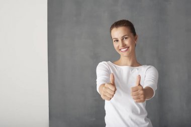 Başparmak gösteren genç bir kadın