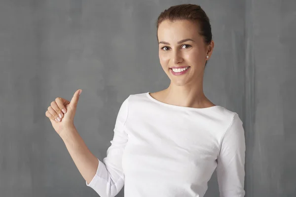 Молодая женщина показывает большие пальцы вверх — стоковое фото