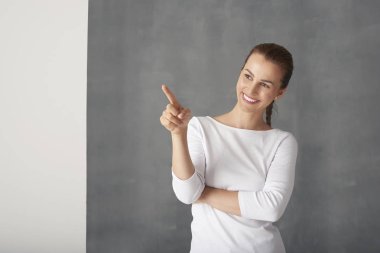 Kadın parmağıyla işaret ediyor.