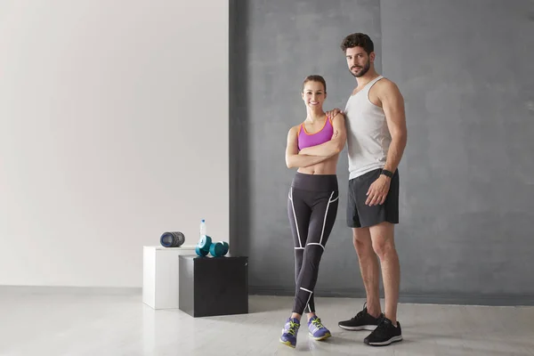 Athletic couple in the gym — Stock Photo, Image
