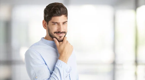 Businessman standing with hand on chin — Stock Photo, Image