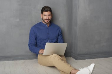 Genç adam laptopunu kullanıyor. 