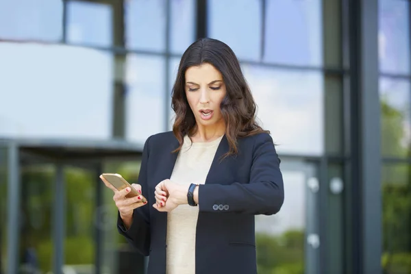 Mujer de negocios comprobar tiempo al aire libre —  Fotos de Stock