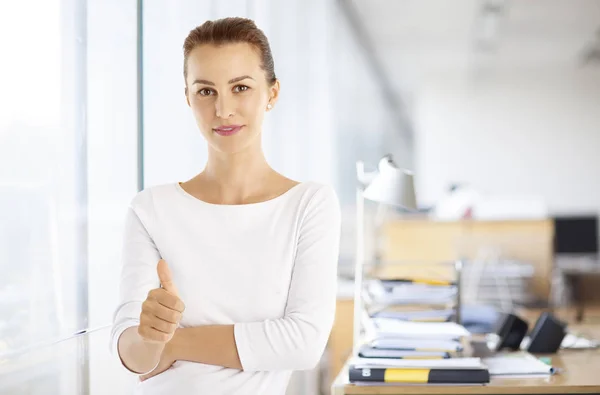 Business woman giving thumb up at office — стоковое фото