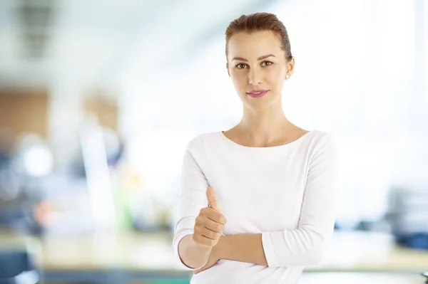 Businesswoman giving thumb up at office — Stock Photo, Image