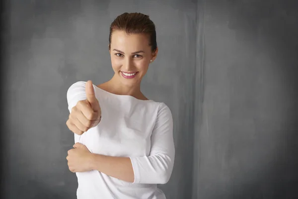 Joven mujer dando pulgar hacia arriba — Foto de Stock