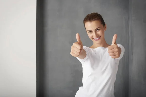 young woman giving thumbs up