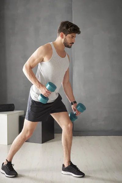 Schöner Mann beim Hantelheben im Fitnessstudio — Stockfoto