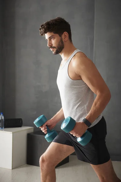 Hombre haciendo ejercicio con pesas en el gimnasio —  Fotos de Stock