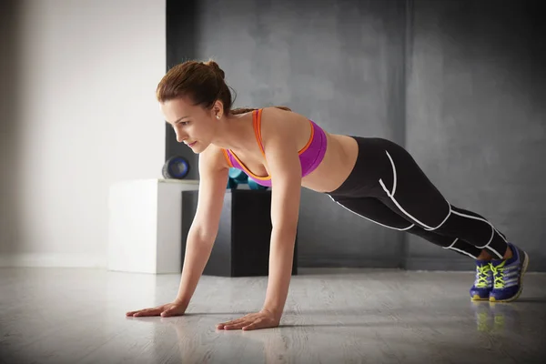 Mujer haciendo ejercicio de tablón en el gimnasio — Foto de Stock