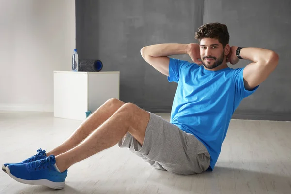 Mann macht Sit-ups im Fitnessstudio — Stockfoto