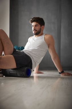 spor salonunda silindir kullanan adam.