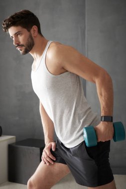 Genç adam dambıl kullanarak