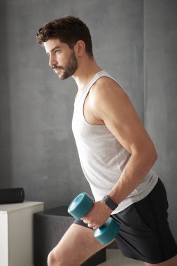 Genç adam dambıl kullanarak