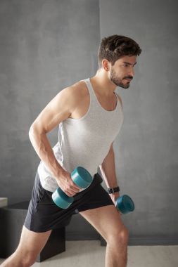 Genç adam dambıl kullanarak