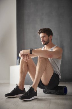 spor salonunda silindir kullanan adam.