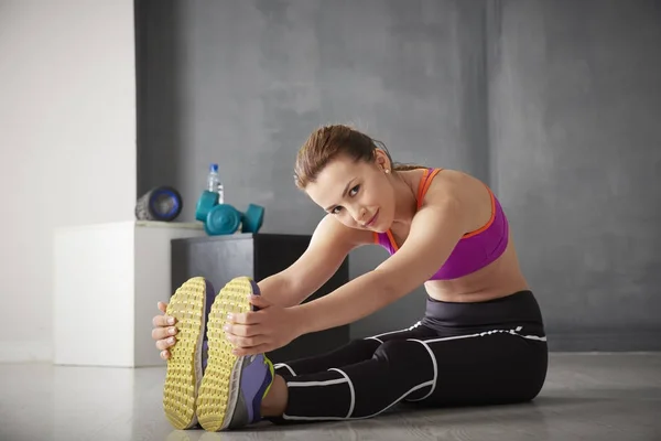 Young woman stretching legs — Stock Photo, Image